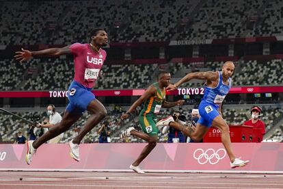 El velocista italiano Lamont Marcell Jacobs, a la derecha, logra el primer puesto en la final masculina de 100 metros.