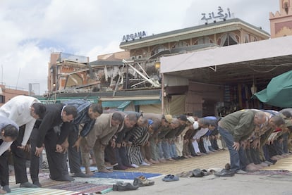 Un grupo de hombres reza ayer ante el café-restaurante Argana, lugar del atentado.