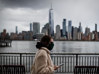 Una mujer con mascarilla camina frente a los rascacielos de Nueva York, en una imagen del 10 de abril.