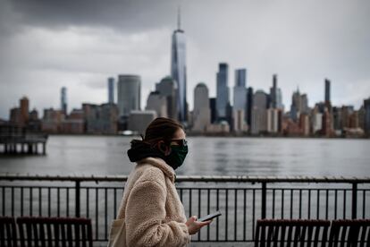 Una mujer con mascarilla camina frente a los rascacielos de Nueva York, en una imagen del 10 de abril.