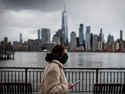 Una mujer con mascarilla camina frente a los rascacielos de Nueva York, en una imagen del 10 de abril.