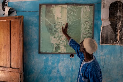 En un mapa que tiene en su casa, Ahmet Sène Diagne enseña cómo era desde arriba Doun Bada Dièye, antes de que el pueblo quedase sumergido por completo en 2012.