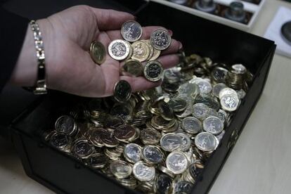 Una mujer sostiene varias monedas de euro reci&eacute;n acu&ntilde;adas.