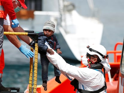 Un niño rescatado de una patera en el Mediterráneo por agentes de salvamento marítimo es bajado a tierra firme en el puerto de Arguineguín, Gran Canaria, el 31 de marzo de 2020.
