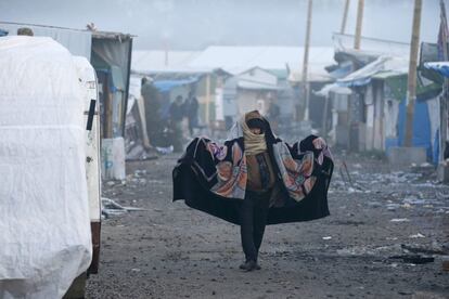 Un migrante camina por una de las zonas del campamento de Calais, en el segundo día de evacuación. 
