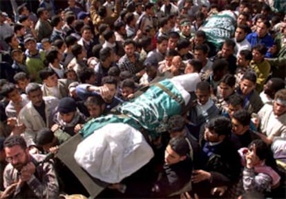 Decenas de personas acompañan los cadáveres de dos palestinos asesinados el lunes en Gaza en una acción que la sociedad palestina atribuye a Israel.