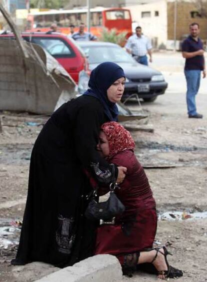 Dos mujeres se lamentan en el lugar del atentado en Bagdad, en el que al menos 28 personas han muerto.