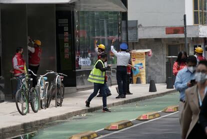 Policías y brigadistas ayudan a evacuar un edificio en Paseo de la Reforma durante el sismo de este lunes.