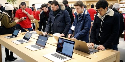 Clientes en una tienda de Apple prueban port&aacute;tiles de la compa&ntilde;&iacute;a de la manzana.