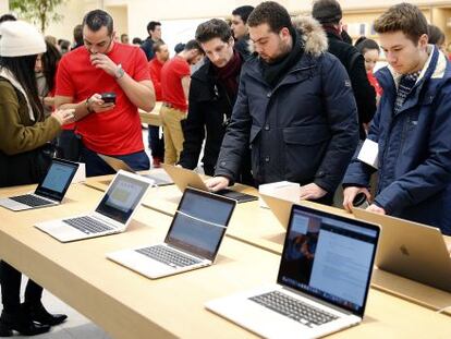 Clientes en una tienda de Apple prueban port&aacute;tiles de la compa&ntilde;&iacute;a de la manzana.