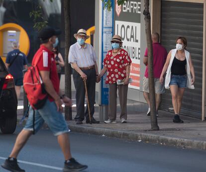 Varias personas pasean por Madrid con mascarillas.