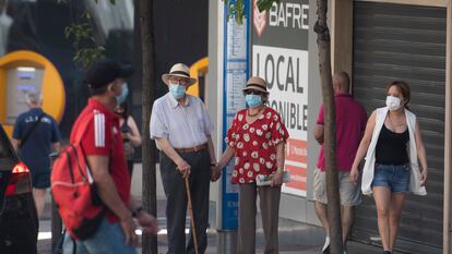 Varias personas pasean por Madrid con mascarillas.