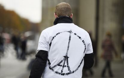 Un joven camina por Berlín (Alemania) con una camiseta dibujada que cambia el símbolo de la paz por la torre Eiffel, como homenaje a las víctimas del atentado.