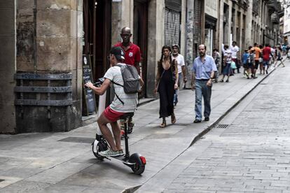 Un home amb un patinet a Barcelona.