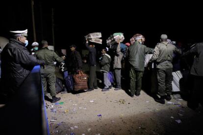 Police and soldiers control refugees at the Tunisian entrance to the border at Ras El Jdir