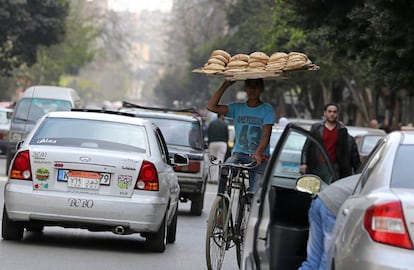 Un vendedor conduce su bicicleta entre el tráfico de la ciudad de El Cairo, el 9 de marzo de 2017.