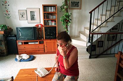 Una mujer habla por teléfono desde su domicilio.