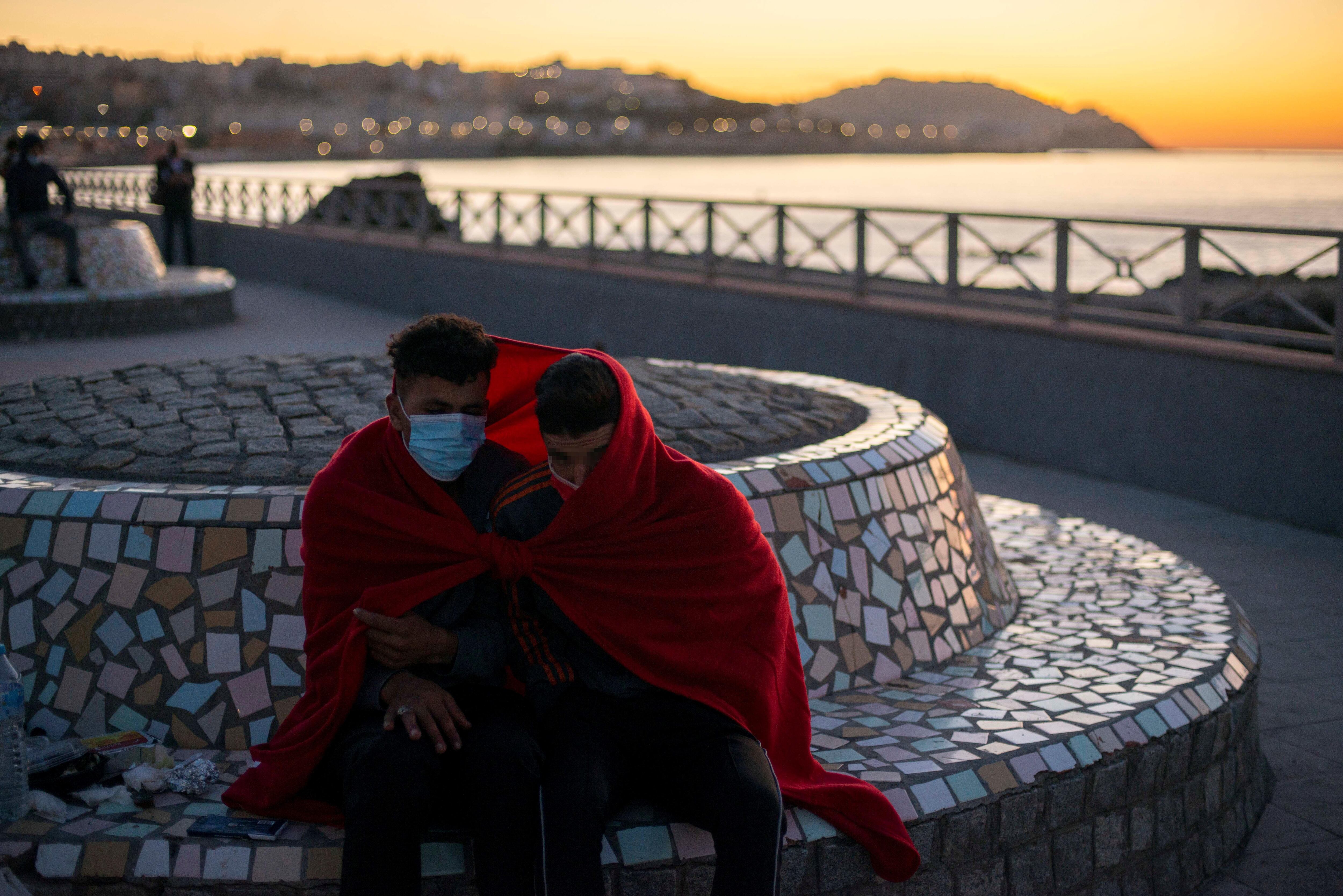  Dos jóvenes inmigrantes se protegen del frío cerca de la playa de El Tarajal.