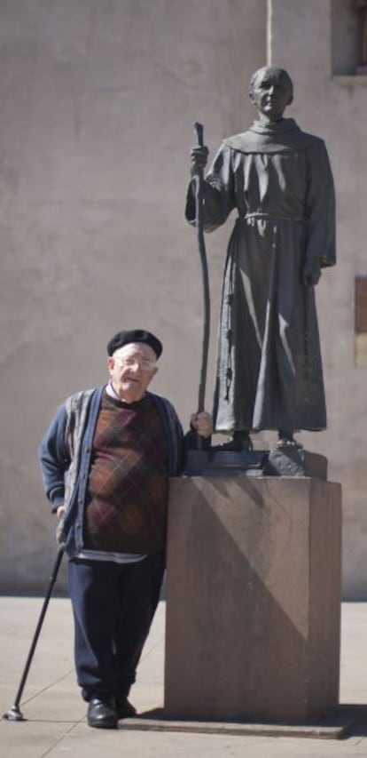 El padre Teodomiro Fuentes, junto a una estatua de Junípero Serra en la misión de San Gabriel, en Los Ángeles.