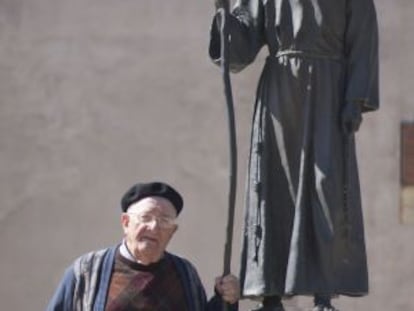 El padre Teodomiro Fuentes, junto a una estatua de Junípero Serra en la misión de San Gabriel, en Los Ángeles.