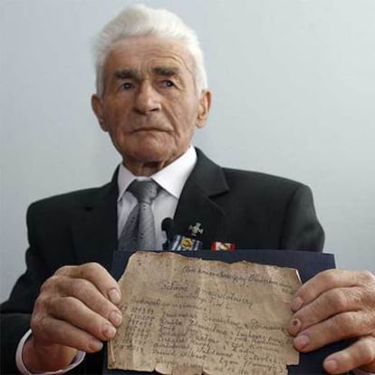 Waclaw Sobczak, antiguo prisionero del campo de concentración de Auschwitz, sostiene el mensaje dejó junto a otros internos en 1944