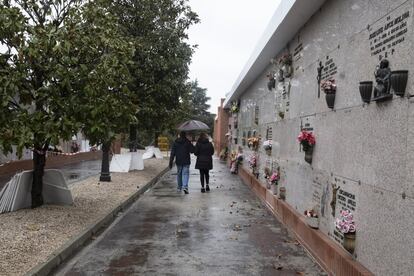 Nuria Martínez, 57 años, camino a su marido. Hoy enterraron al hermano de ella. Solo pudieron venir ellos dos porque su madre y otro hermano se encuentran en cuarentena. Nuria arrancó una flor de la corona para llevársela a su madre. "No hemos podido ni abrazarnos".