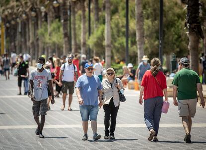 Personas con y sin mascarilla en el paseo marítimo de la playa Malvarrosa de Valencia.