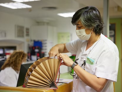 Una trabajadora del hospital Clínic consulta unos archivos durante la caída de los sistemas informáticos.