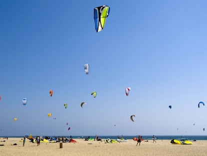 Un grupo de bañistas hacen volar sus cometas en la playa de Tarifa, Cádiz.