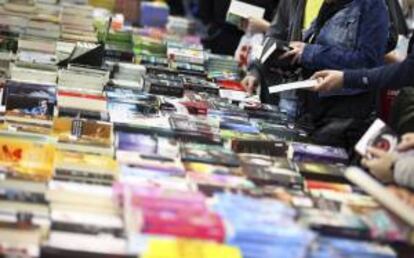 Visitiantes buscan libros en un expositor. EFE/Archivo