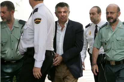 16 de mayo de 2006.<br>Juan Antonio Roca sale esposado y custodiado por policías y guardias civiles tras prestar declaración en los juzgados de Marbella por su implicación en el 'caso Malaya'. Un mes antes, el 20 de abril, la policía intervino 200.000 euros en en el interior de un maletín escondido en una finca murciana de Roca