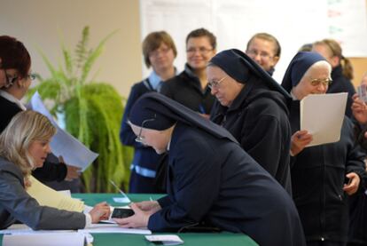 Dos religiosas realizan los trámites previos al voto en un colegio electoral de Varsovia.