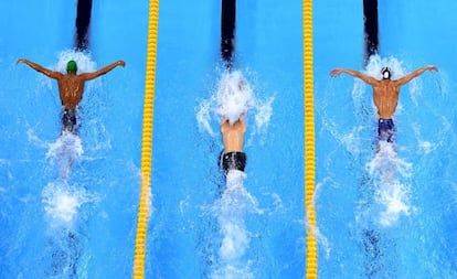 Chad le Clos (i) y Michael Phelps (d) nadando la semifinal de 200m mariposa con el húngaro Tamas Kenderesi en medio.