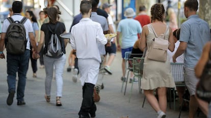 Un camarero trabaja en una terraza del Paseo de Gracia. en Barcelona