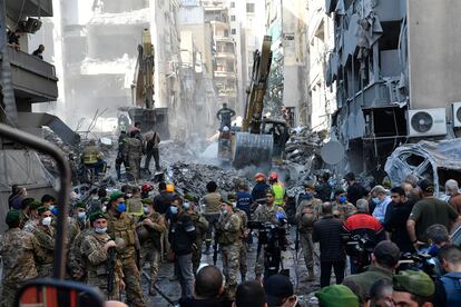 Soldados, periodistas y personal de emergencias, ante los restos del edificio destruido por un ataque israelí este sábado en el centro de Beirut.