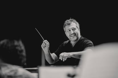 Componist en dirigent Thomas Adès, met de dirigeerstok in de hand.