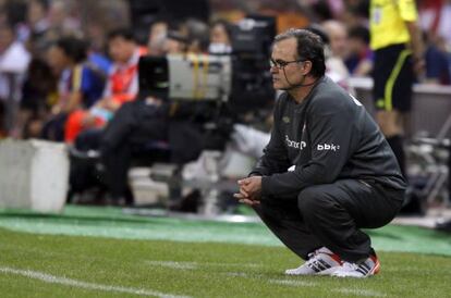 Bielsa observa de cuclillas un partido del Athletic.