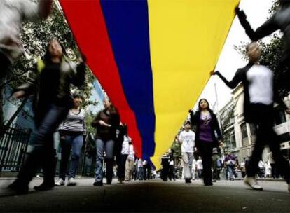 Los manifestantes sujetan una gran bandera colombiana durante la marcha en Bogotá.