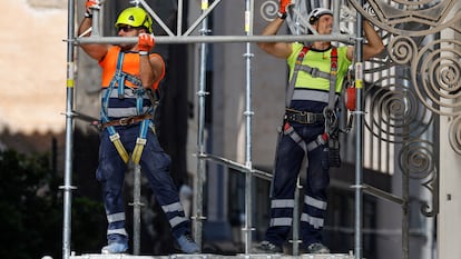 Dos trabajadores montan un andamio en una obra en la ciudad de Valencia