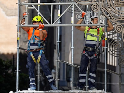 Dos trabajadores montan un andamio en una obra en la ciudad de Valencia