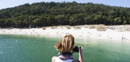 Una visitante fotograf&iacute;a la playa de Rodas, en las islas C&iacute;es, desde la cubierta del barco procedente de Vigo.