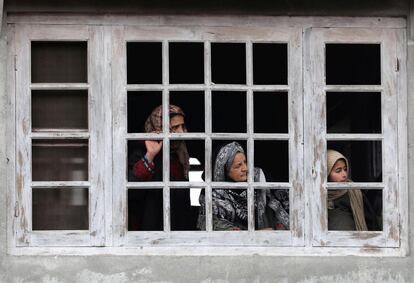 Mujeres cachemiras observan desde una ventana el cortejo fúnebre del militante Tauseed este miércoles en el pueblo de Nowpora (India). Seis combatientes han muerto en dos enfrentamientos con fuerzas de seguridad de la India en los dos últimos días en la Cachemira india.
