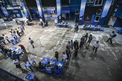 Eleitores aguardam na fila para votar na favela da Rocinha, no espaço da escola de samba Acadêmicos da Rocinha, no Rio de Janeiro. 142,8 milhões de cidadãos irão às urnas hoje para escolher o próximo presidente do Brasil e 14 dos 27 governadores que chegaram ao segundo turno.