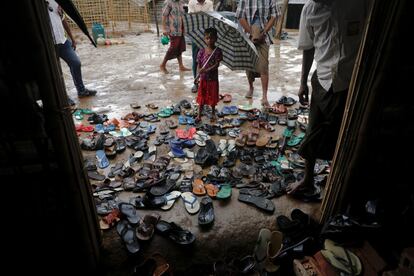 Una niña sujeta un paraguas durante la llegada de refugiados rohingya a la mezquita del campo de refugiados para el rezo del viernes cerca de Cox's Bazar, Bangladés.