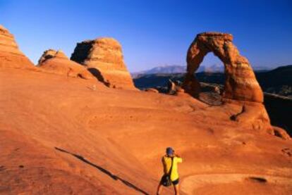 Un turista fotografía Delicate Arch, en el parque nacional Arches, en Utah (EE UU).