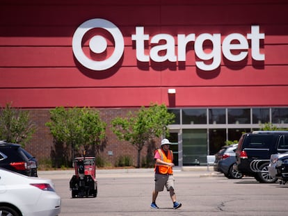 A worker collects shopping carts in the parking lot of a Target store on June 9, 2021, in Highlands Ranch, Colorado.