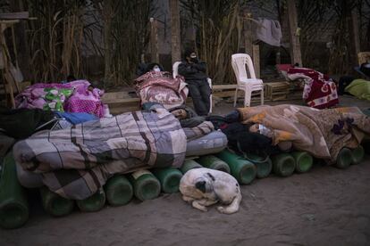 Personas duermen sobre cilindros de oxígeno vacíos a la espera de que abra una tienda para rellenar sus tanques, en el barrio de Villa El Salvador, mientras continúa la falta de oxígeno médico para tratar a los pacientes con covid-19 en Lima, Perú.