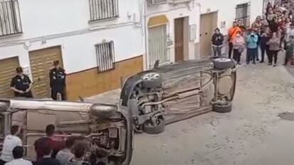 Dos vehículos volcados por manifestantes en Casariche (Sevilla) este lunes, en presencia de agentes de la Policía Local.