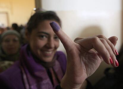 Una mujer muestra su dedo manchado de tinta tras ejercer su derecho al voto en la primera ronda de las elecciones legislativas, en un colegio electoral en Kasr al-Aini, El Cairo.