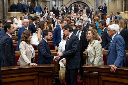 Salvador Illa (en el pasillo) estrecha la mano de Pere Aragonès al finalizar el pleno de investidura en el Parlament, este jueves.